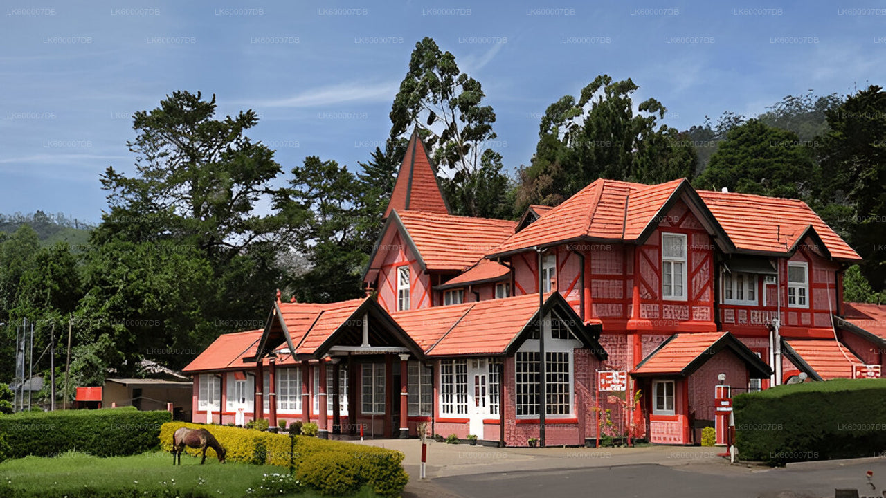 Red and white building with a tiled roof in a lush green landscape