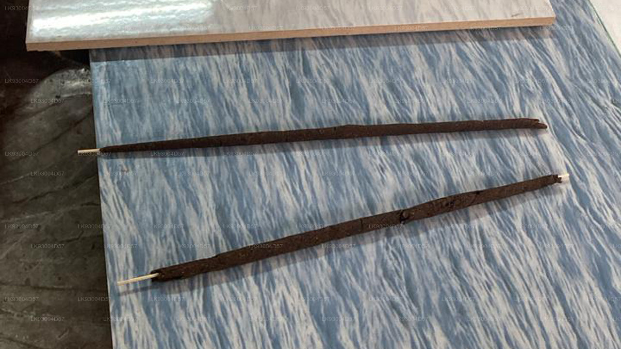 Two Cinnamon Incense sticks on a blue marbled surface
