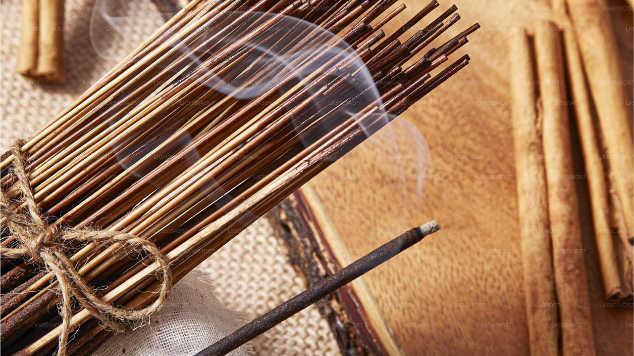 Bundled incense sticks tied with twine on a textured surface