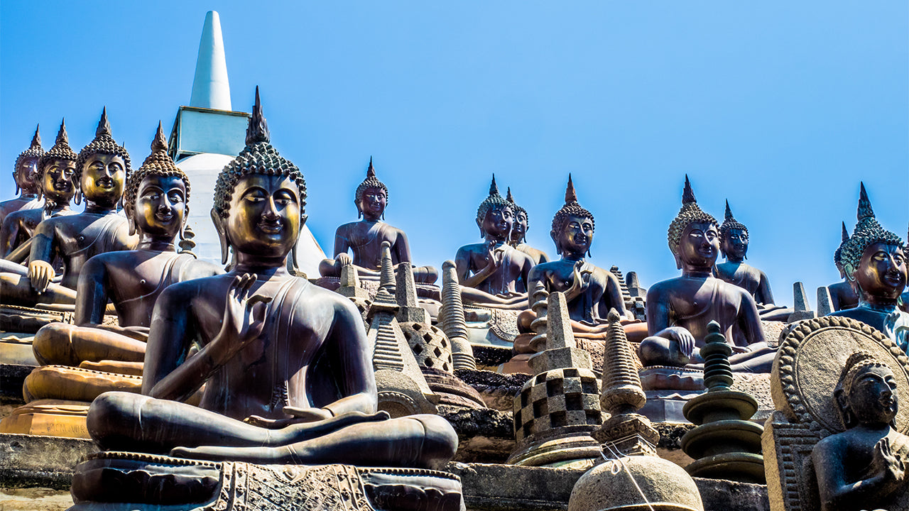 Row of Buddha statues with a clear blue sky background