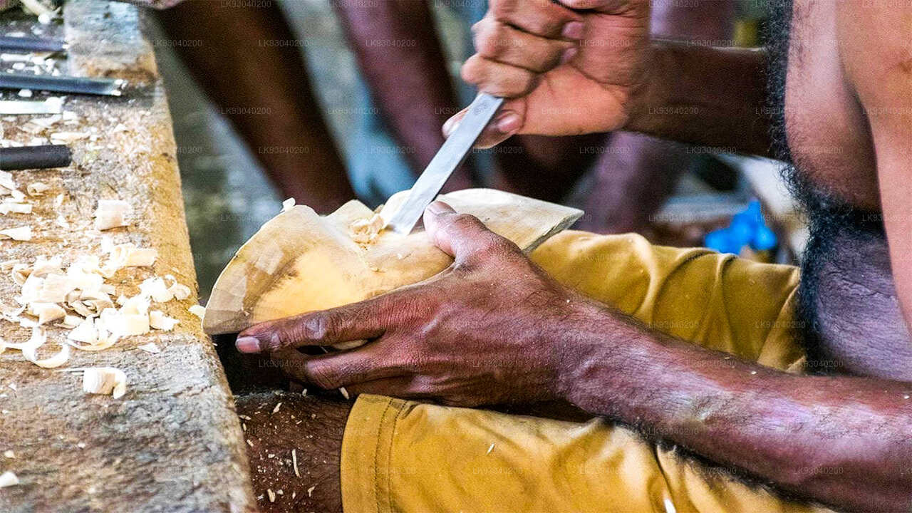 A person carving a wooden mask following traditional Sri Lankan techniques.
